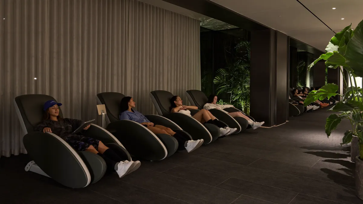 Hotel recovery lounge with massage chairs and compression boots